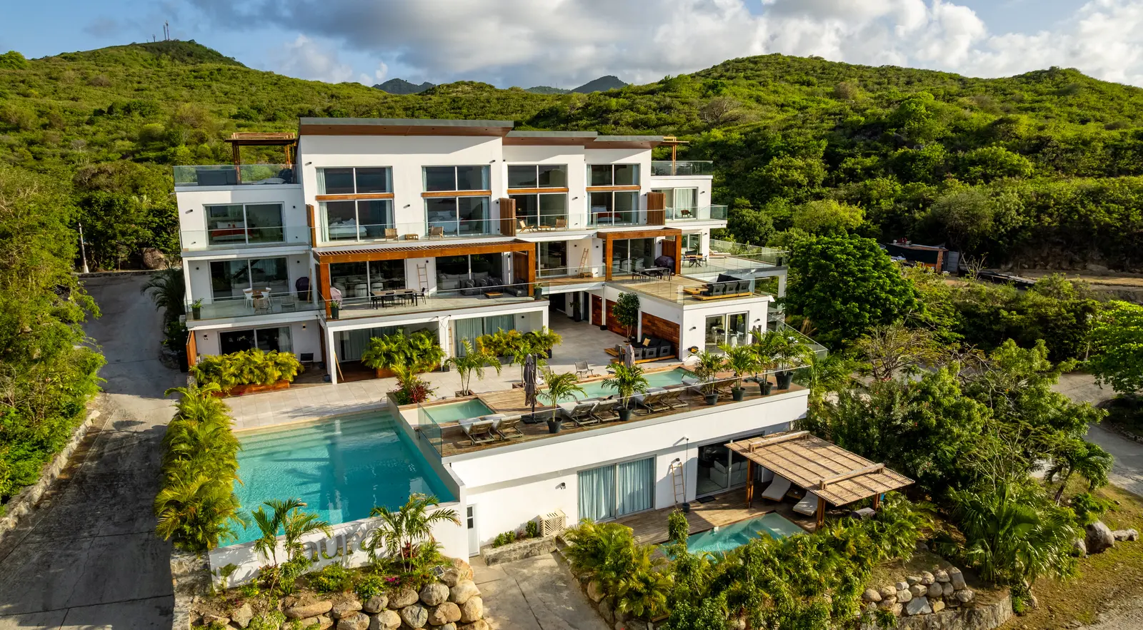 Aerial view of the Aura residence, its terraces and pools above Anse Marcel.