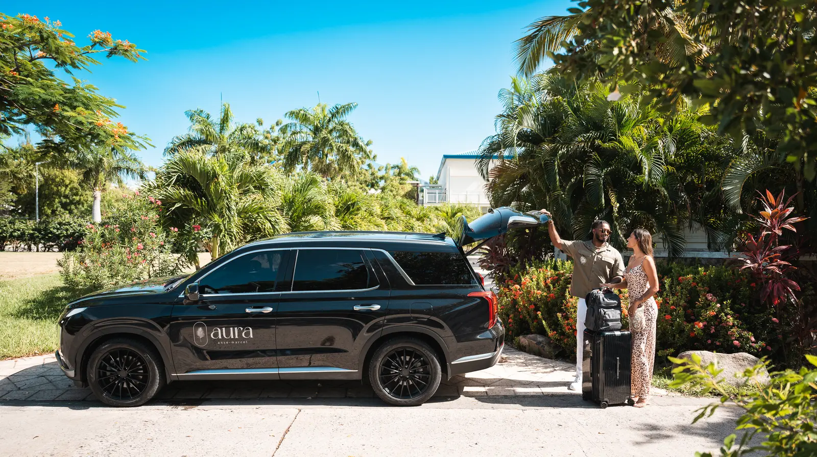 Guests unloading their luggage from the Aura car in front of the residence.