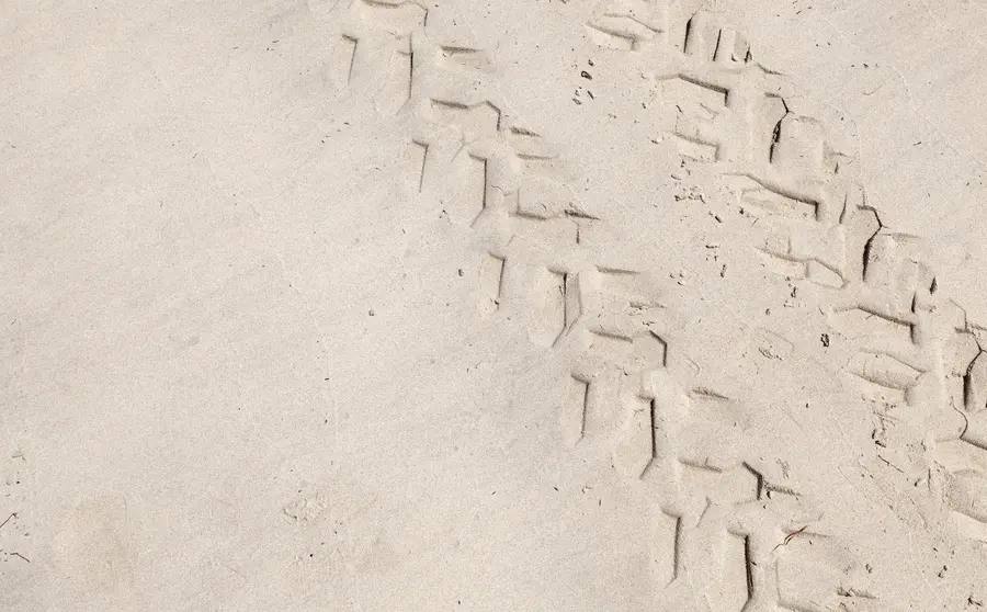 Tyre tracks in white sand.