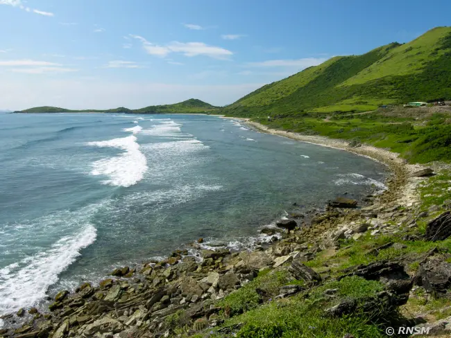 Rocky coastline and green hills of Saint-Martin.