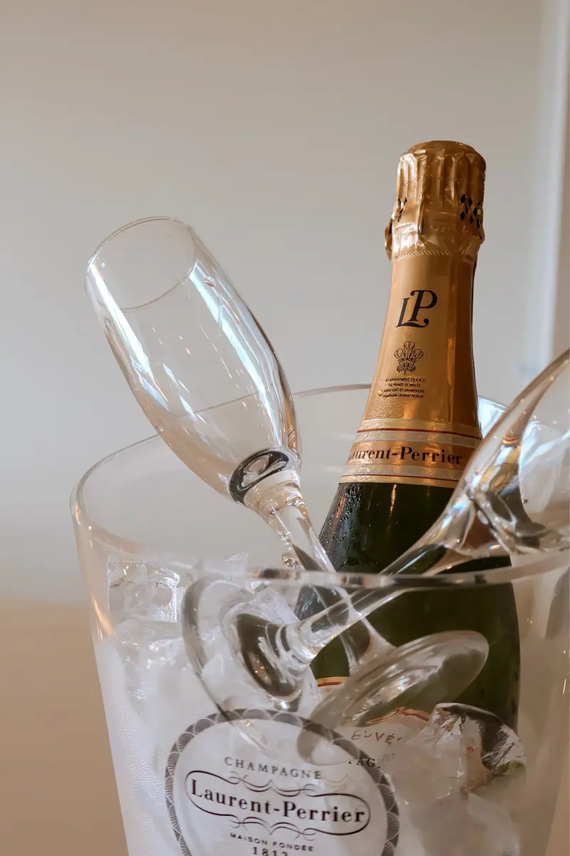 Champagne bottle and glasses in an ice bucket.