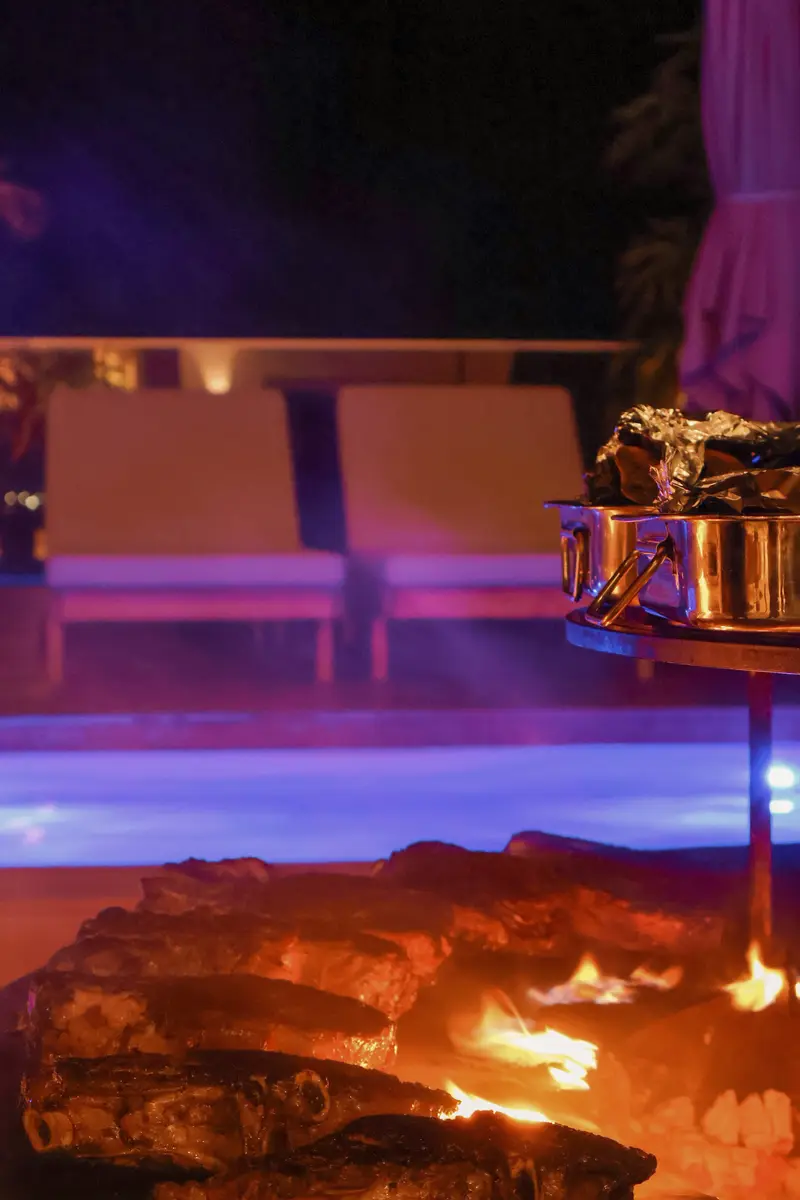 Lounge chairs by a fire pit at night.