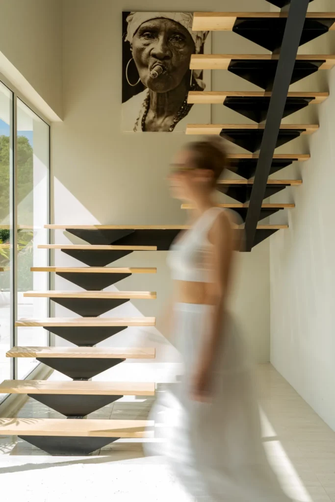 Floating wooden staircase in a two-level Aura villa.