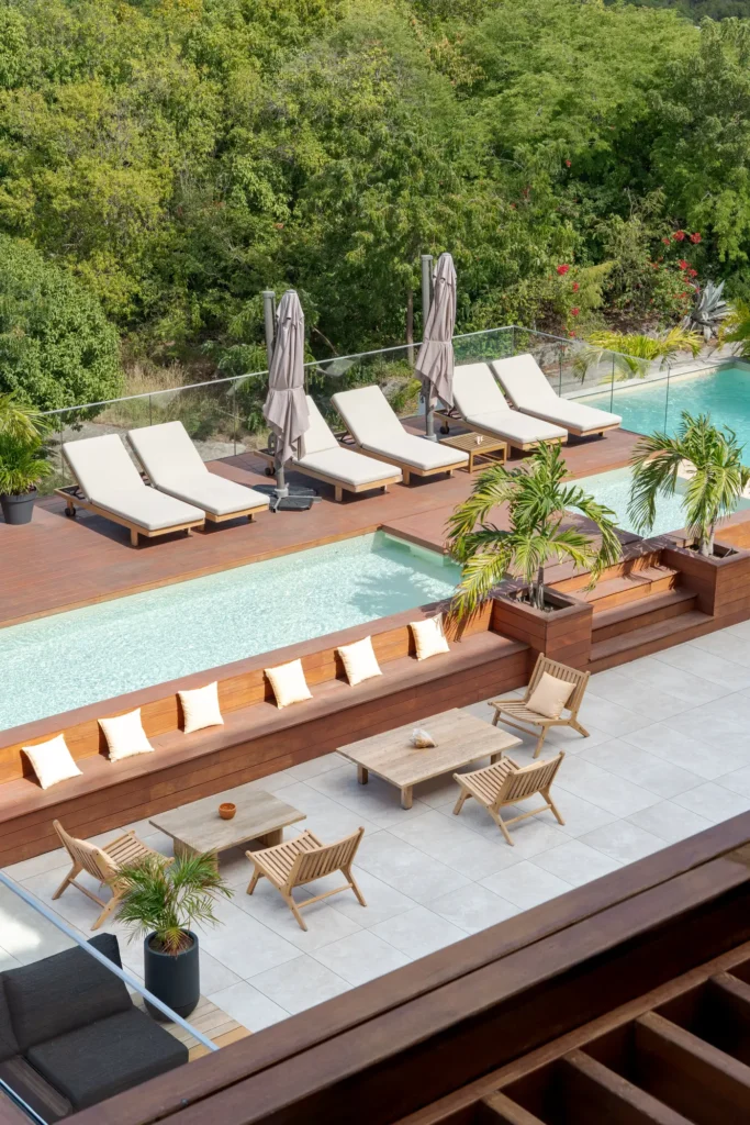 Wooden terrace with pool and sun loungers.