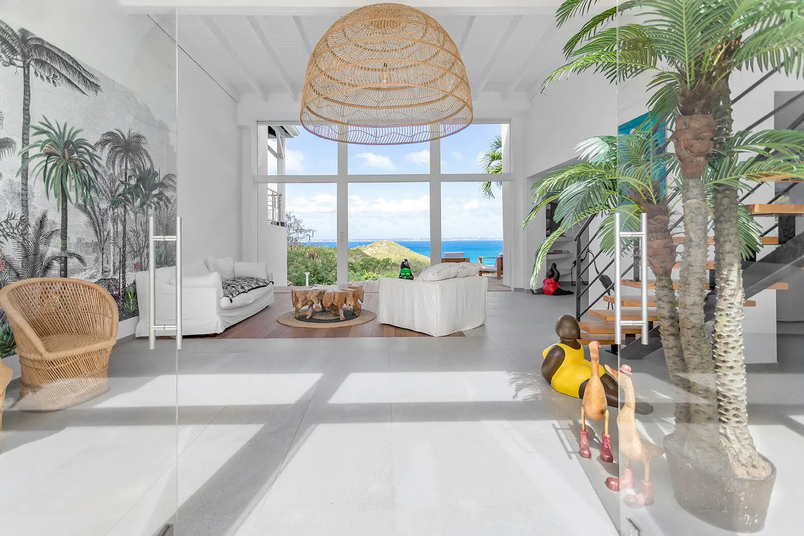 High-ceiling living room of Caye Blanche with a rattan lamp.