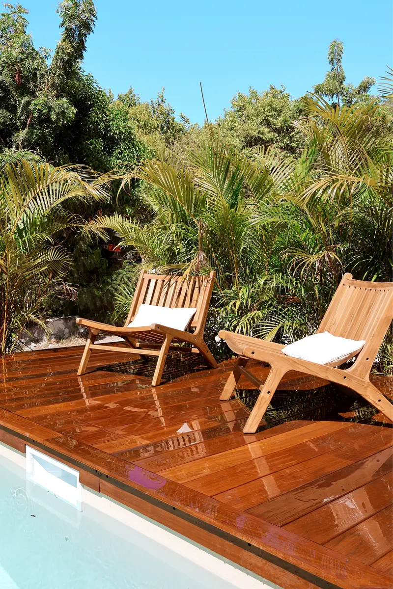 Wooden chairs on a pool terrace.